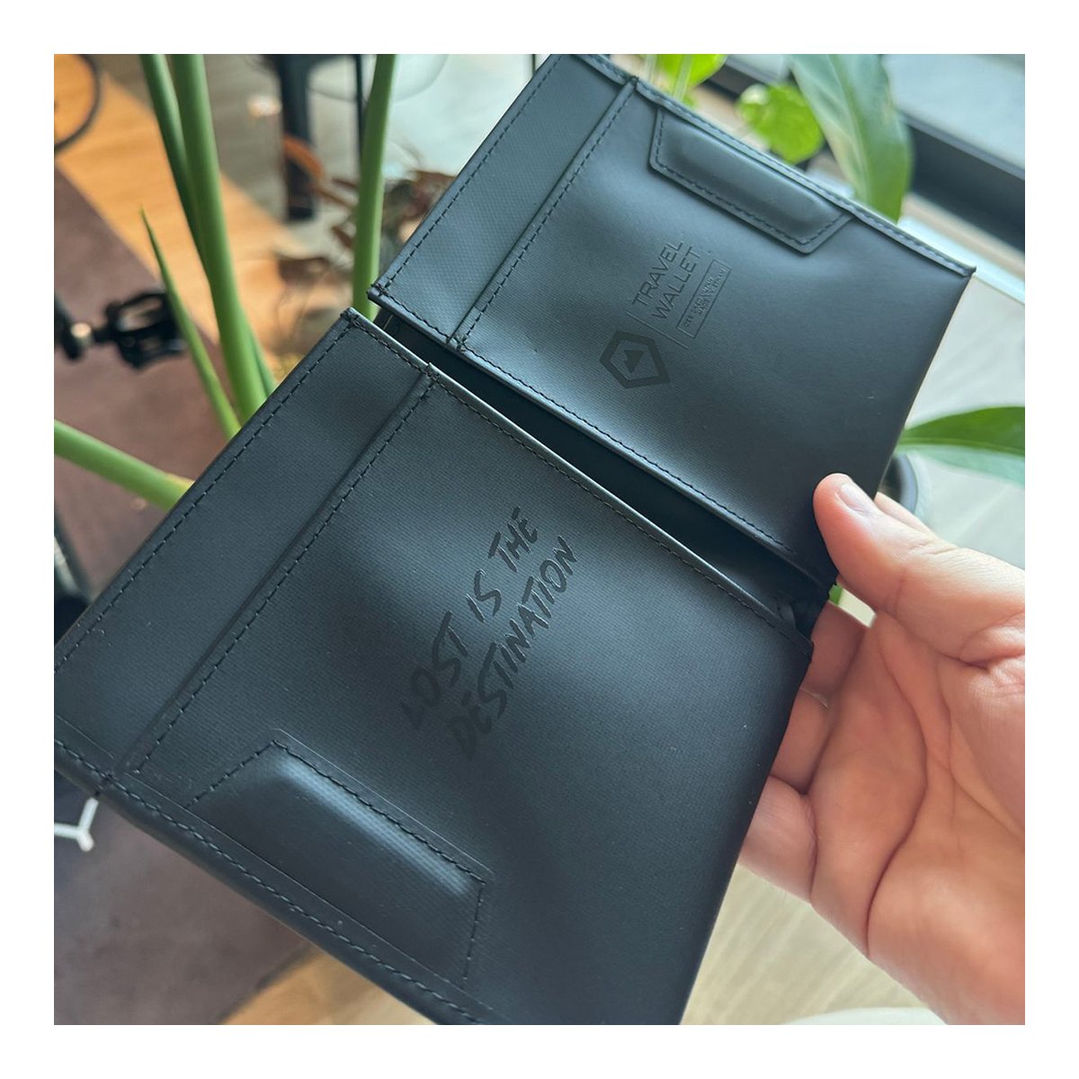 WANDRD Travel Wallet - Innenansicht der schwarzen Reisegeldbörse mit den Schriftzügen "LOST IS THE DESTINATION" und "TRAVEL WALLET