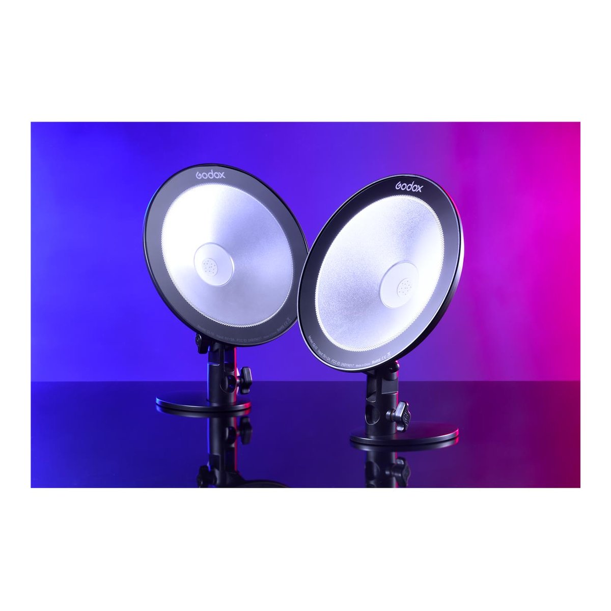 Godox CL10 Ambient LED Licht - Zwei Godox Studioleuchten von vorne, mit reflektierenden Oberflächen auf Ständern vor blau-rotem Hintergrund