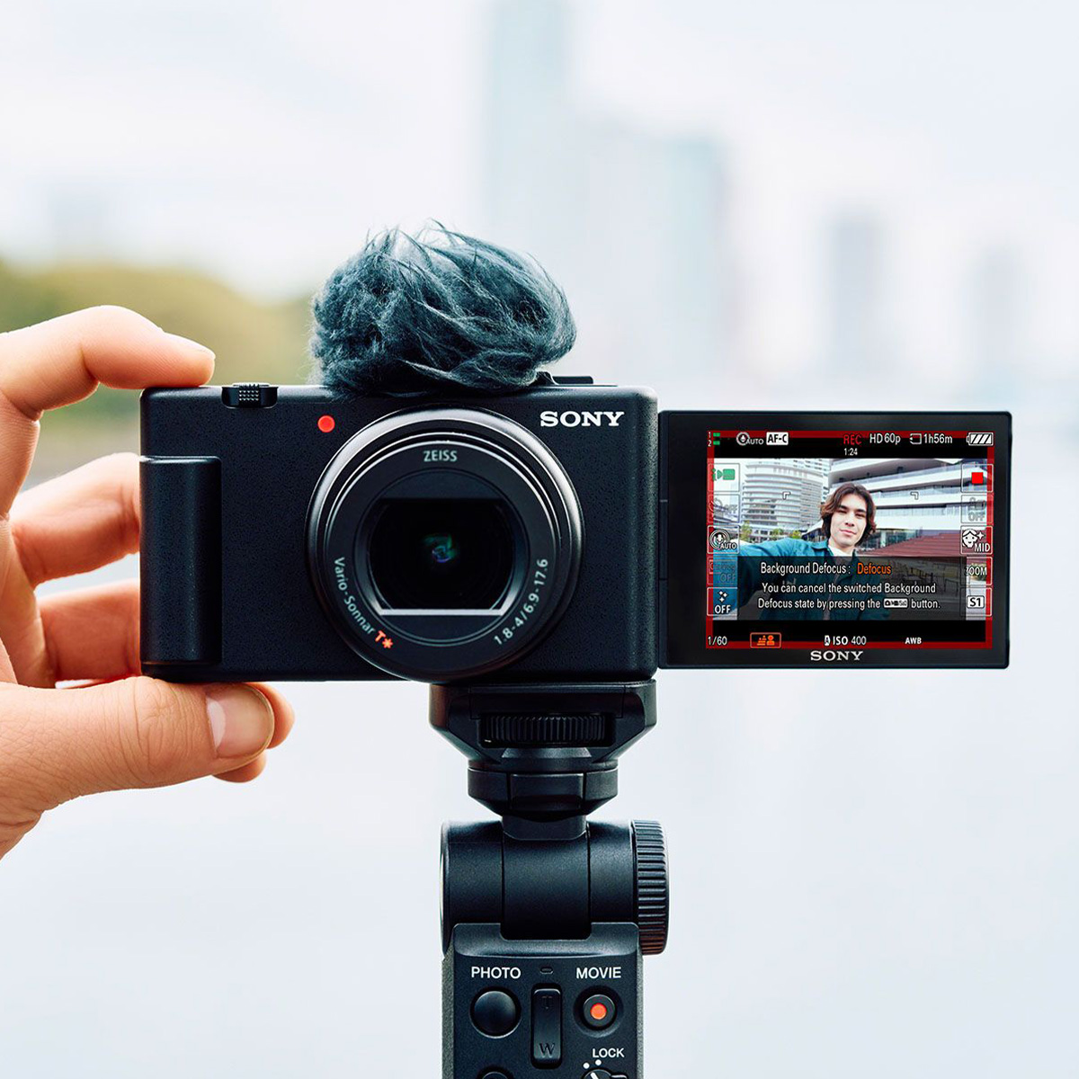 Sony ZV-1 II Vlog Kamera mit Sony GP-VPT2Bt Handgriff und Mikrofon mkit Poppschutz sowie offenem Display im Selfie Modus