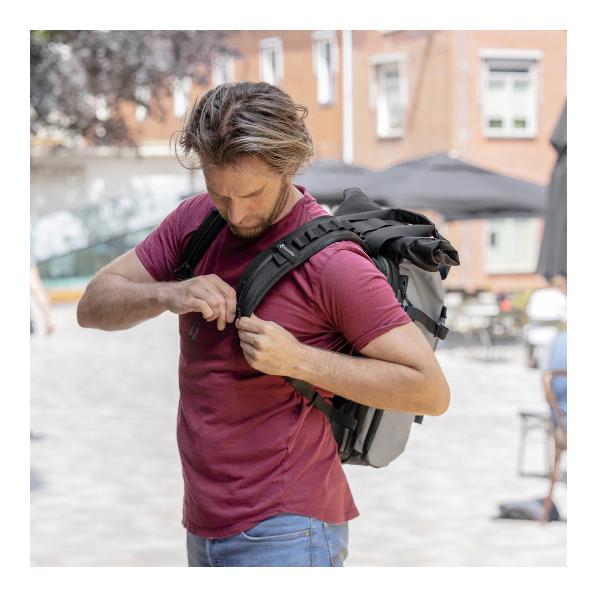 WANDRD PRVKE 31-Liter DisNet Grey Photo Bundle - Anwendungsbeispiel: Mann stellt Rucksackriemen an der Brust ein