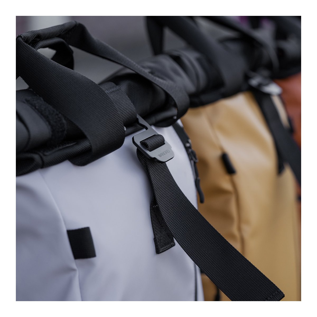 WANDRD PRVKE Lite 11-Liter Uyuni Purple - Detailansicht der oberen Gurtbefestigung und Schnalle eines hellen Rucksacks.