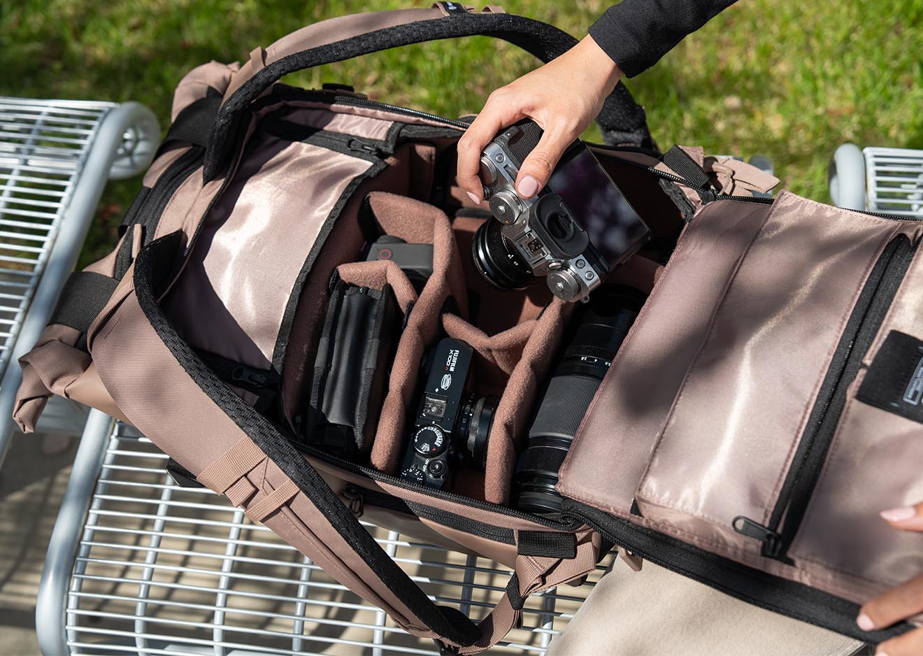 Wandrd PRVKE V4 – Flexibler Zugriff auf die Kamera unterwegs ffener PRVKE V4 Rucksack in Braun mit Kamera-Setup auf einer Parkbank