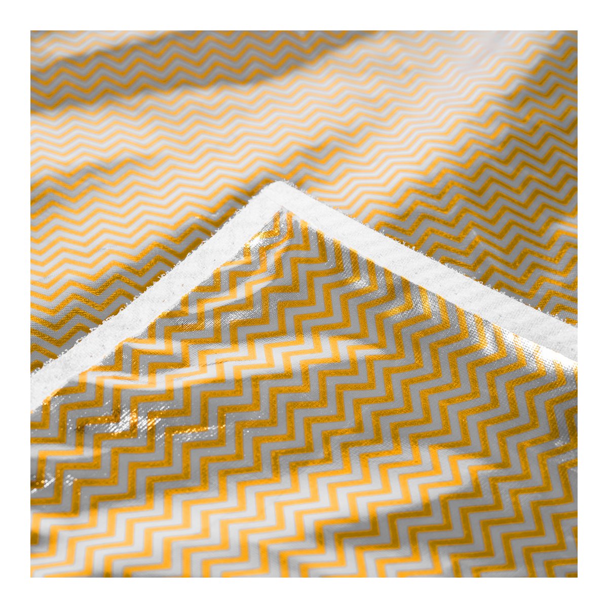Caruba Curved Gesichtsreflektor Pro Set- 180cm x 65cm (inkl. Erweiterungsset) - Detailansicht des gelb-grauen Zickzackmusters auf Stoff, mit einer gefalteten Kante.