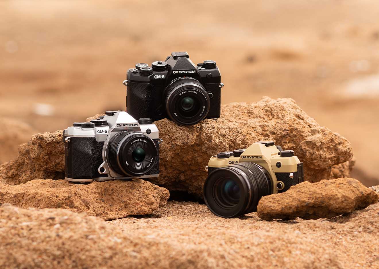 OM SYSTEM OM-5 Mark II in Schwarz, Silber und Sand Beige auf Felsen