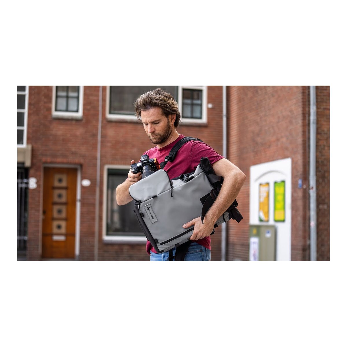 WANDRD PRVKE 41-Liter DisNet Grey Photo Bundel V3 - Anwendungsbeispiel: Mann verstaut Kamera in grauer Messenger-Fototasche WANDRD PRVKE 41-Liter DisNet Grey Photo Bundel V3 - Anwendungsbeispiel: Mann verstaut Kamera in grauer Messenger-Fototasche