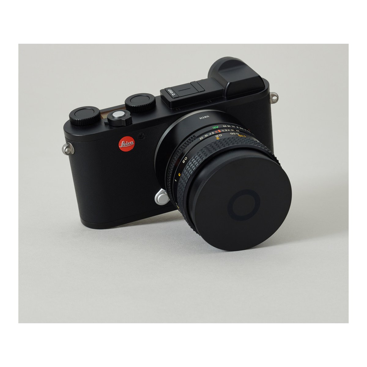 Urth 67mm Magnetic Lens Filter Caps - Schrägansicht: Schwarze Leica Kamera mit Objektiv und Deckel