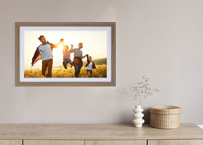 Digitaler Rollei Smart Frame 212 in Holzoptik zeigt Familienfoto an der Wand