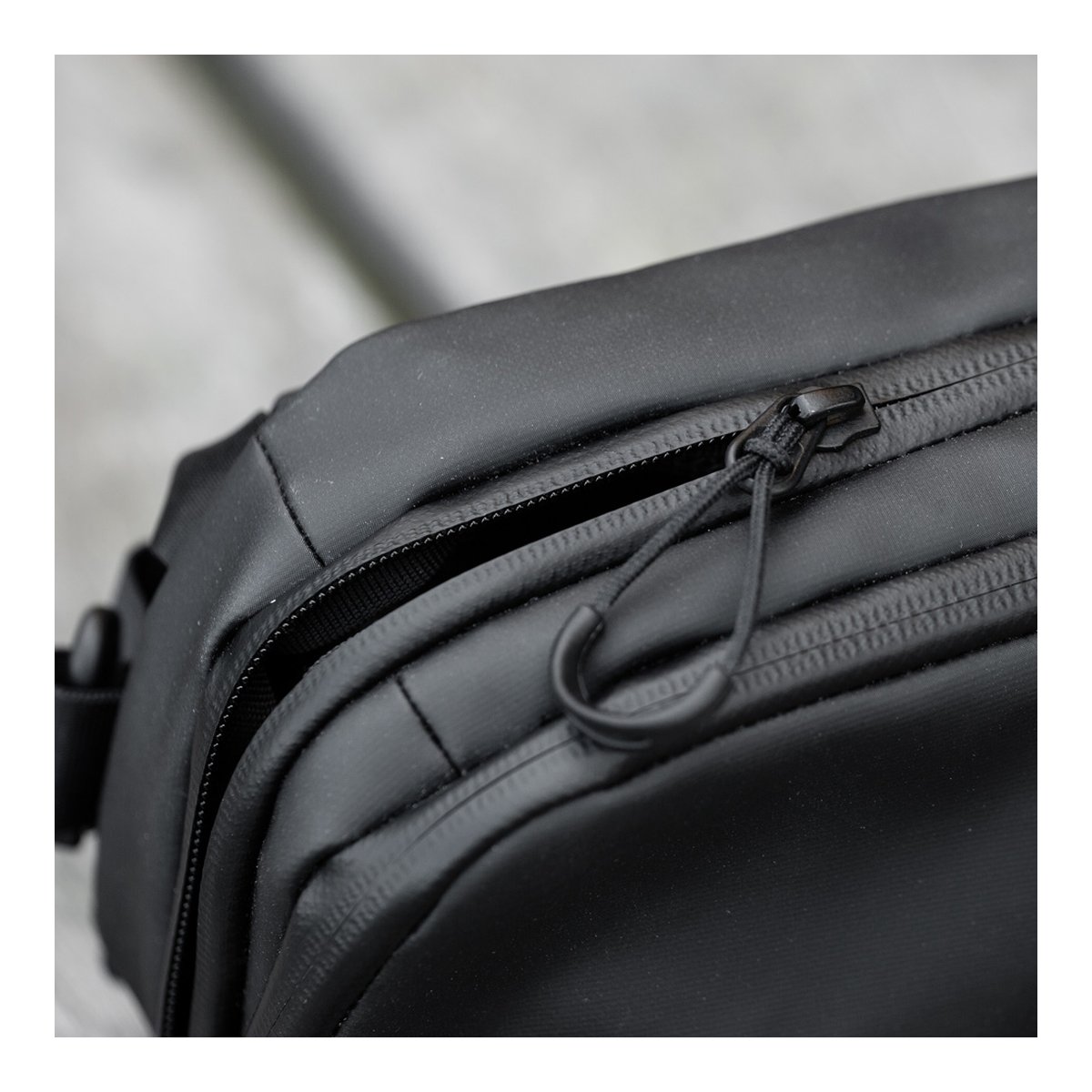 WANDRD Tech Bag Large - Grosse Organizer-Tasche (3,5 Liter) - Detailansicht Reißverschluss mit Zugschlaufe an schwarzer, wasserabweisender Tasche.