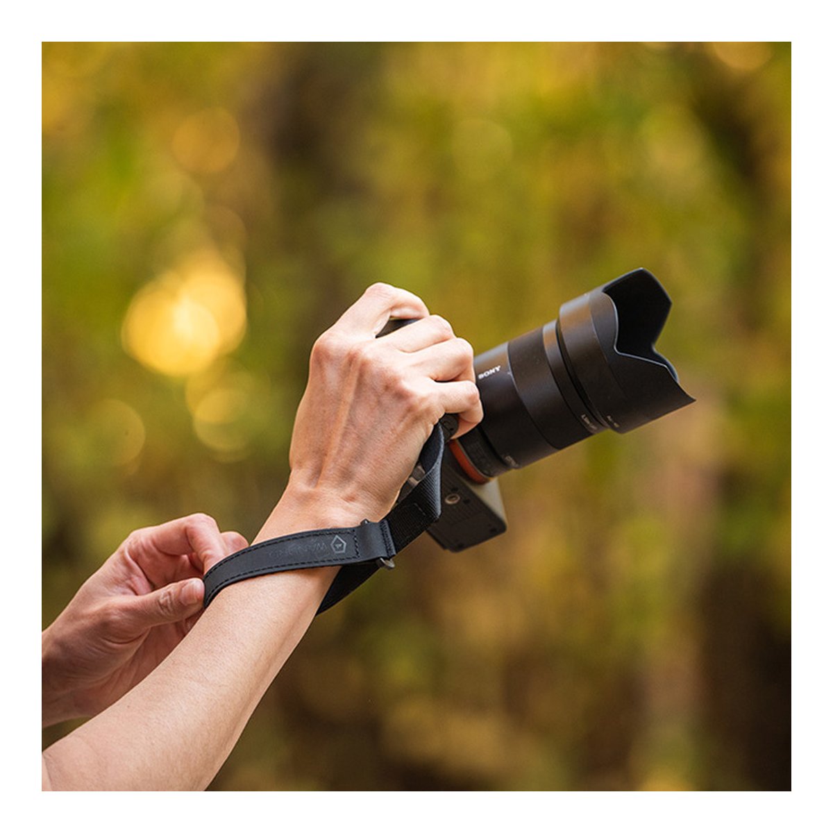 WANDRD Wrist Strap - Anwendungsbeispiel: Kameragurt am Handgelenk, an Kamera befestigt.