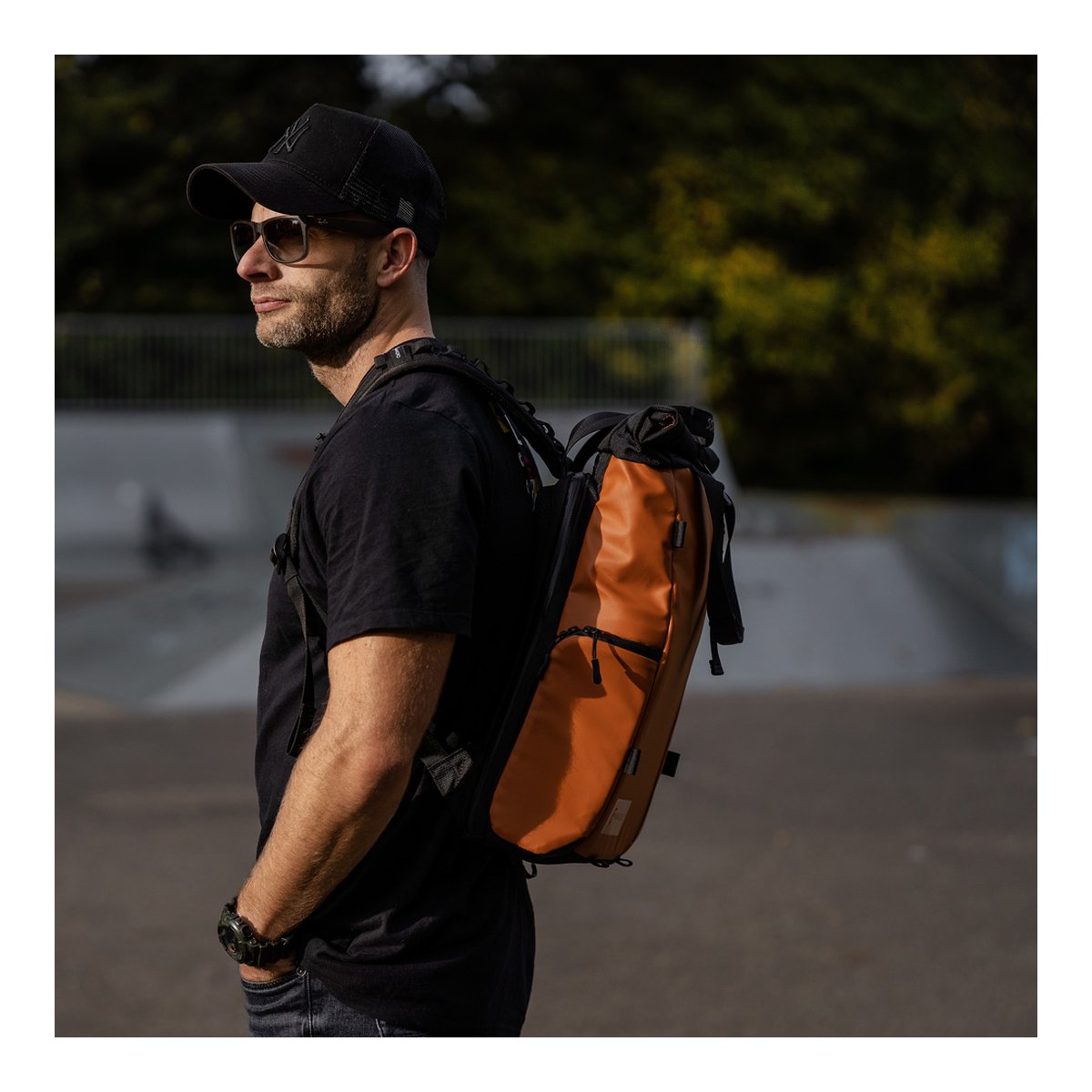 WANDRD PRVKE Lite 11-Liter Sedona Orange - Anwendungsbeispiel: Mann trägt orange-schwarzen Rucksack seitlich