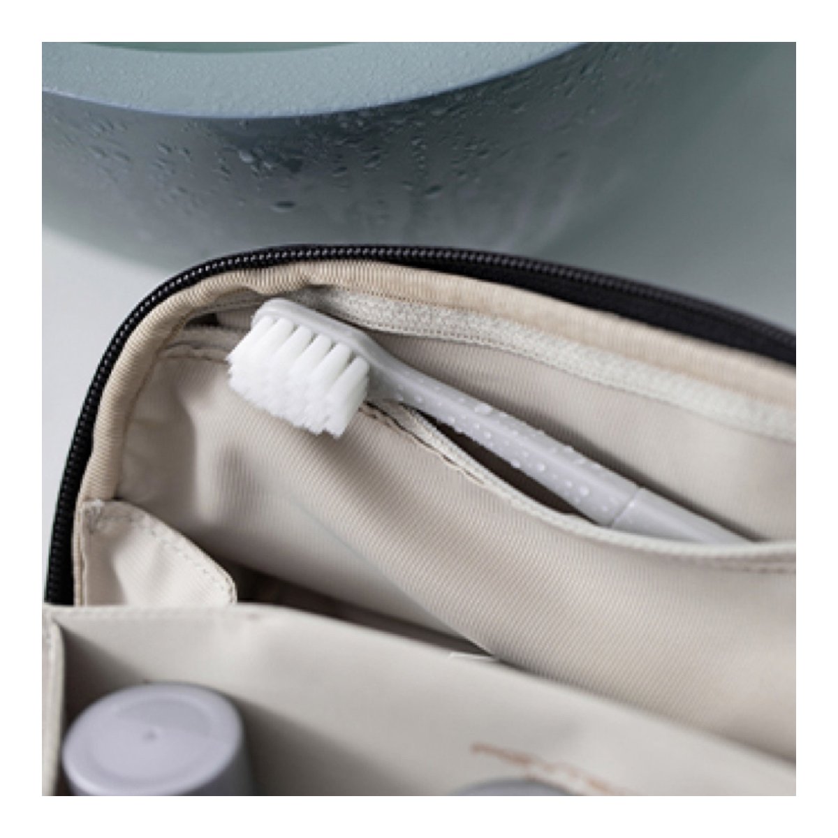 PGYTECH Wash Pouch(Twilight Black) - Detailansicht: Geöffnete Kulturtasche mit nasser Zahnbürste in einem Seitenfach