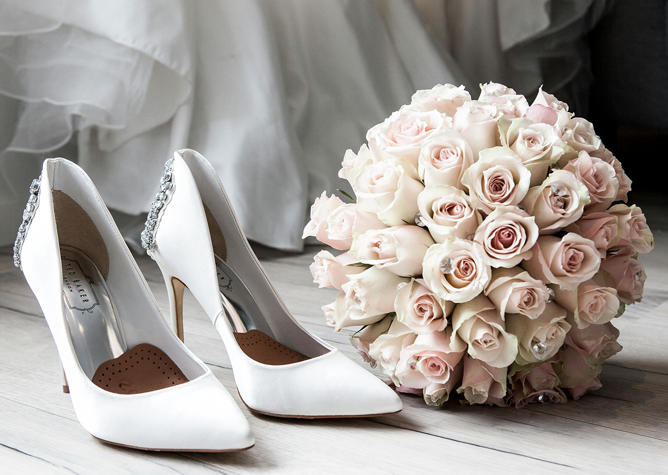 Hochzeitsdetails – Brautschuhe und Rosenstrauß in Nahaufnahme Weiße Brautschuhe und roséfarbener Rosenstrauß – stilvolle Detailaufnahme für die Hochzeitsreportage
