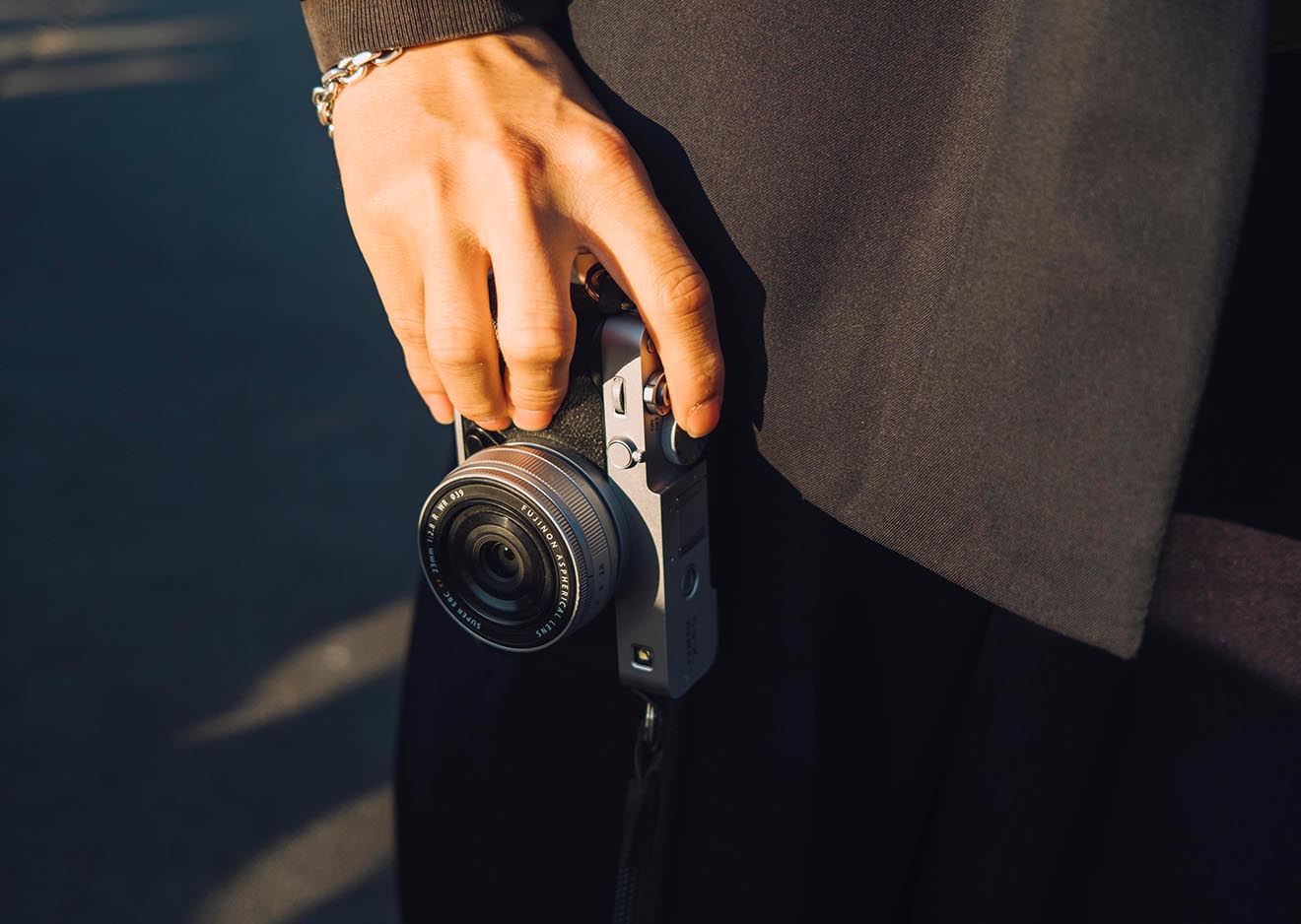 Hand hält die silberne Fujifilm X-E5 mit kompaktem XF23mm Objektiv – perfekter Begleiter für Reisen und Alltag