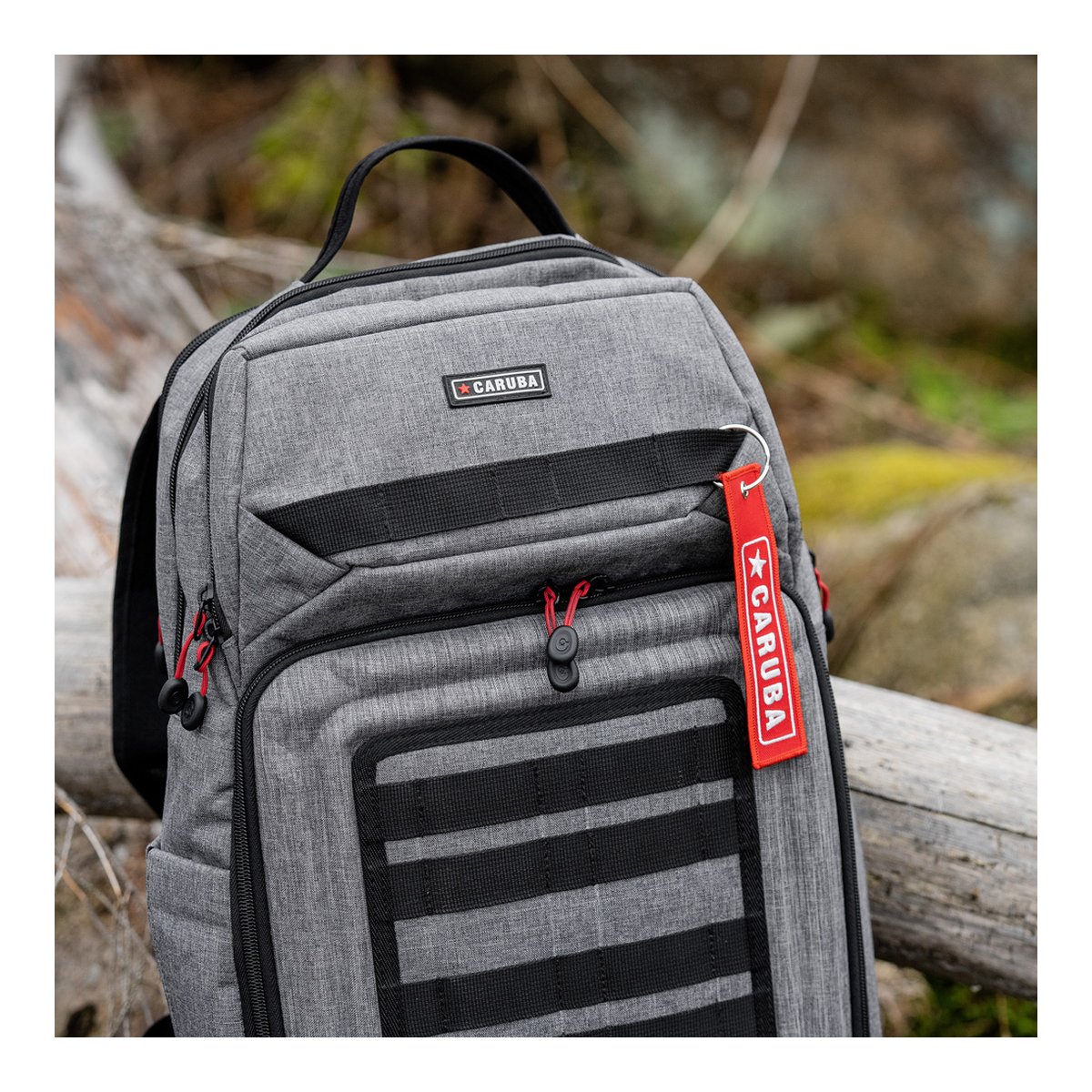 Caruba Skyline 100 Drohnenpack Grau - Detailansicht: Grauer Caruba Rucksack mit Logo-Patch und rotem Anhänger