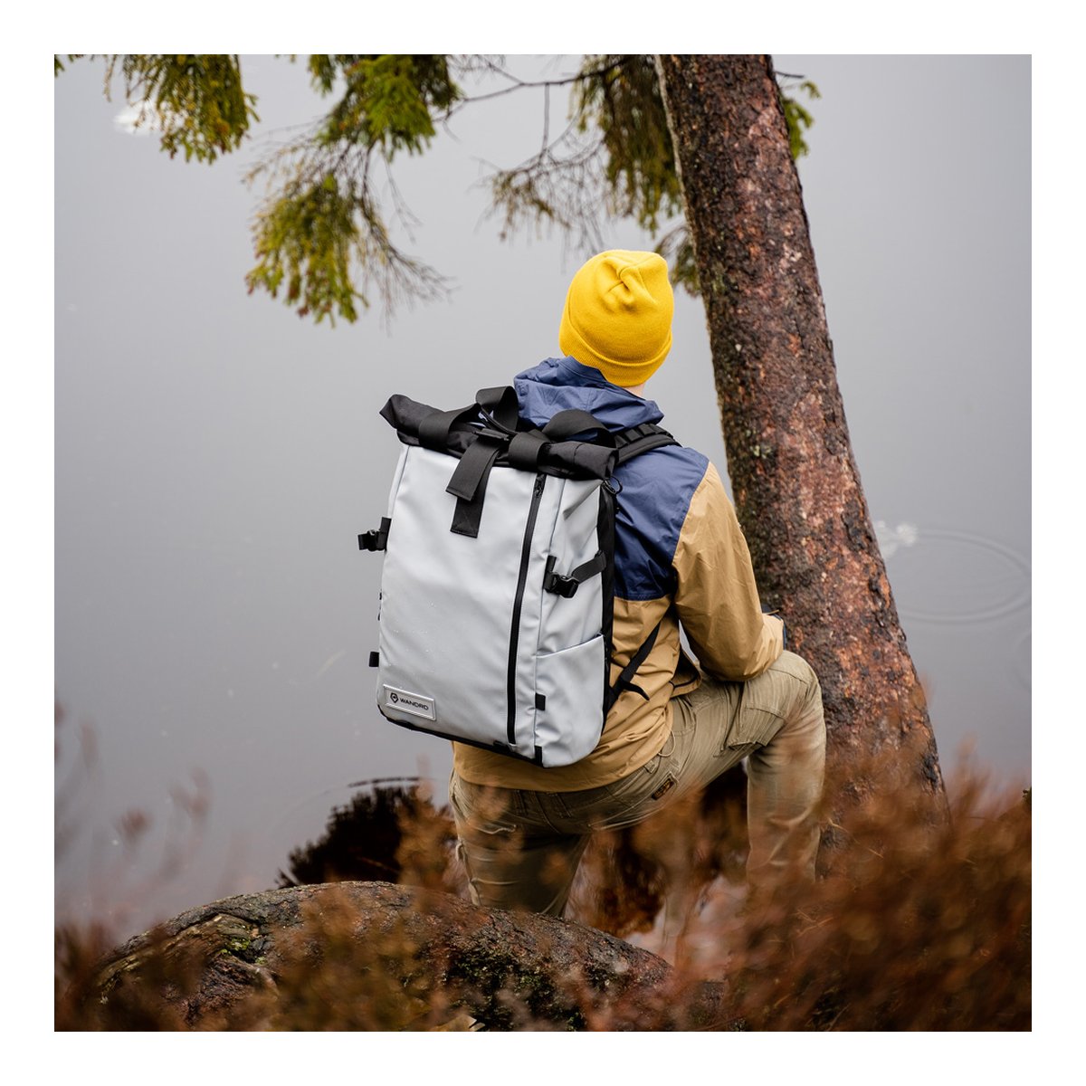 WANDRD PRVKE 41-Liter DisNet Grey Photo Bundel V3 - Anwendungsbeispiel: Roll-Top-Rucksack von hinten an Person, Blick auf See WANDRD PRVKE 41-Liter DisNet Grey Photo Bundel V3 - Anwendungsbeispiel: Roll-Top-Rucksack von hinten an Person, Blick auf See