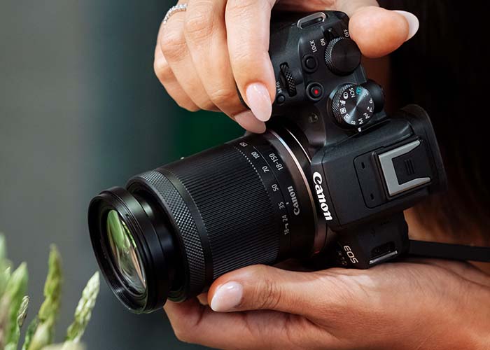 Canon EOS R10 mit RF-S Objektiv in der Hand gehalten