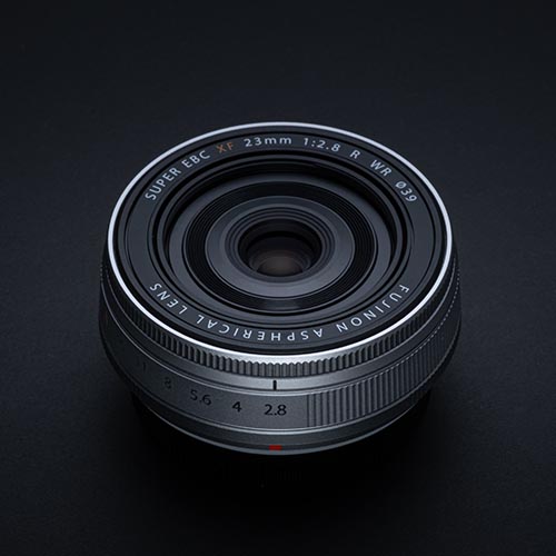 Frontansicht des FUJINON XF23mmF2.8 R WR Objektivs in Silber vor schwarzem Hintergrund