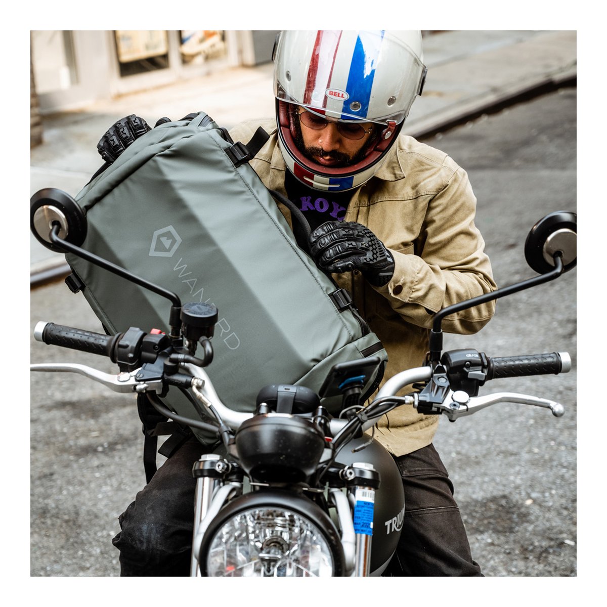 WANDRD HEXAD CARRYALL DUFFEL 40-Liter Wasatch Green - Anwendungsbeispiel: Biker belädt Motorrad mit grauer WANDRD Tasche.