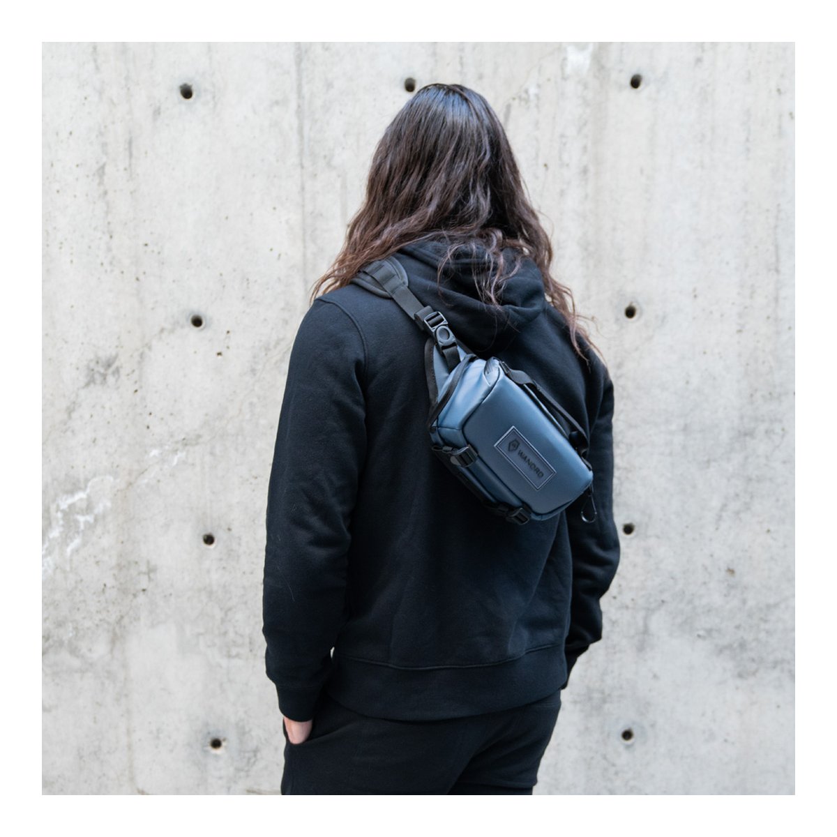 WANDRD ROGUE Sling 3L Aegean Blue - Anwendungsbeispiel: Person von hinten mit dunkelblauer Sling Bag über der Schulter