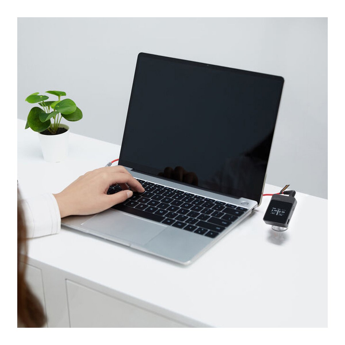 Godox MoveLink M1 - Anwendungsbeispiel: USB-Messgerät in Verwendung neben Laptop; Hand tippt, Werte sichtbar am Display.