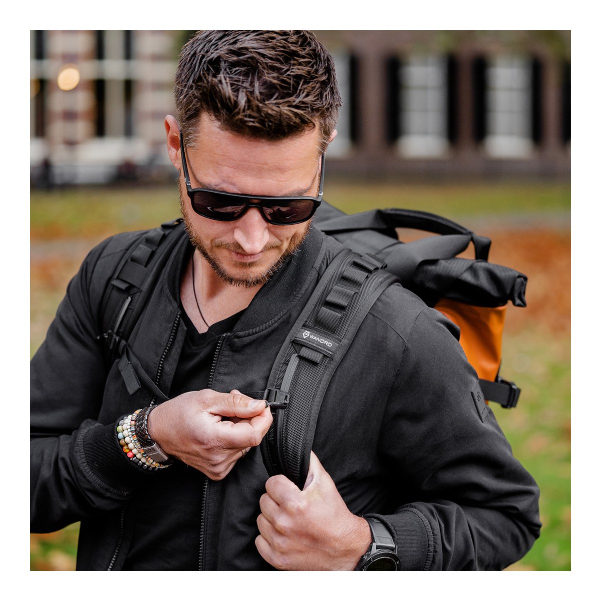 WANDRD PRVKE 21-Liter Sedona Orange Photo Bundle V3 - Anwendungsbeispiel: Mann justiert den Brustgurt seines WANDRD Rucksacks.