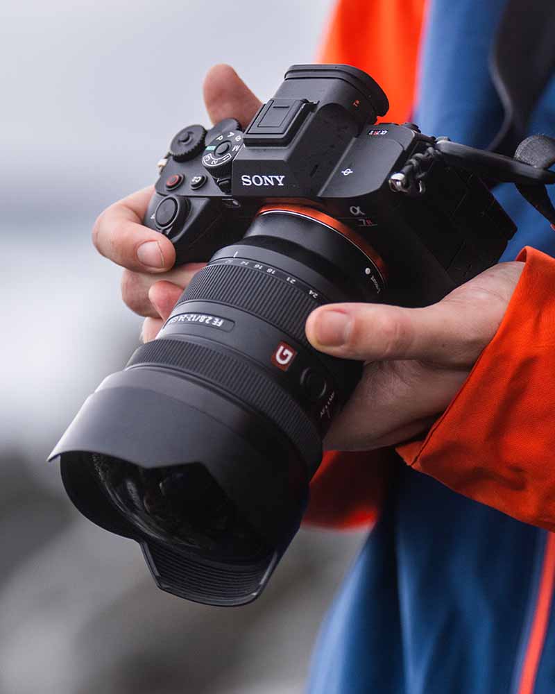Sony Alpha 7R V in den Händen eines Fotografen, ausgestattet mit einem G-Master-Objektiv. Hochauflösende Vollformatkamera für Landschafts- und Porträtfotografie.