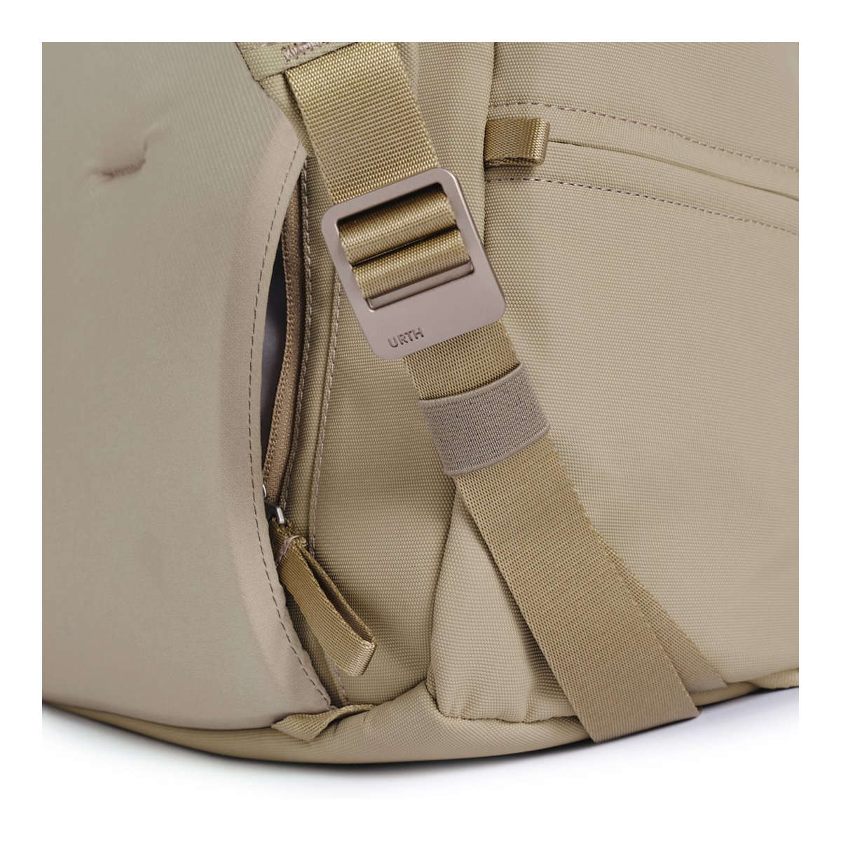Urth Arkose 20L Rucksack (Beige) - Detailansicht Seitentasche und Schultergurt einer beigen Tasche mit URTH-Schnalle