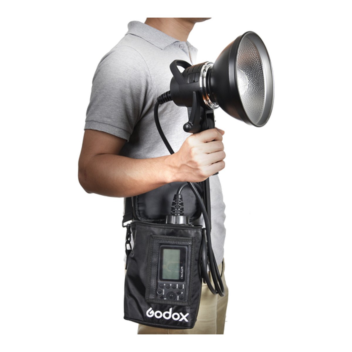 Godox 1200ws externer Blitzkopf AD1200 Godox Halterung - Anwendungsbeispiel: Person hält Godox Blitzkopf und trägt Akkupack in Tasche