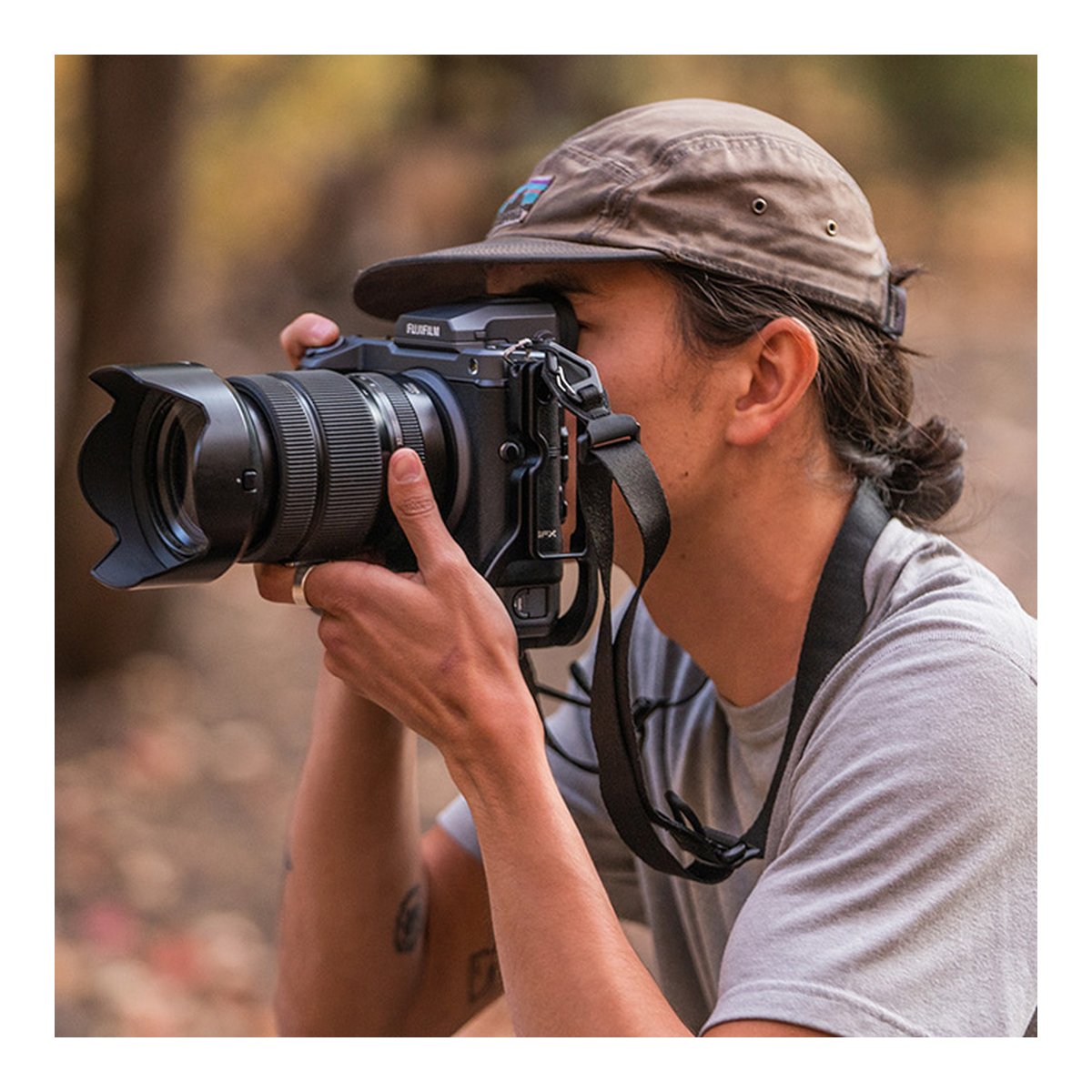 WANDRD Sling Strap - Anwendungsbeispiel: Kamera mit Gurt in Nutzung durch Fotografen; Seitenansicht