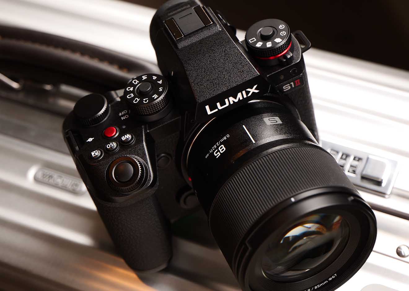 Panasonic Lumix S1II mit 85 mm Objektiv für Porträts und Video Panasonic S1II mit montiertem 85mm Objektiv auf einem Aluminiumkoffer