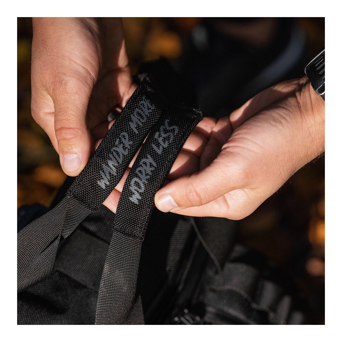 WANDRD PRVKE 21-Liter Sedona Orange Photo Bundle V3 - Detailansicht der Träger mit Text 'WANDER MORE WORRY LESS