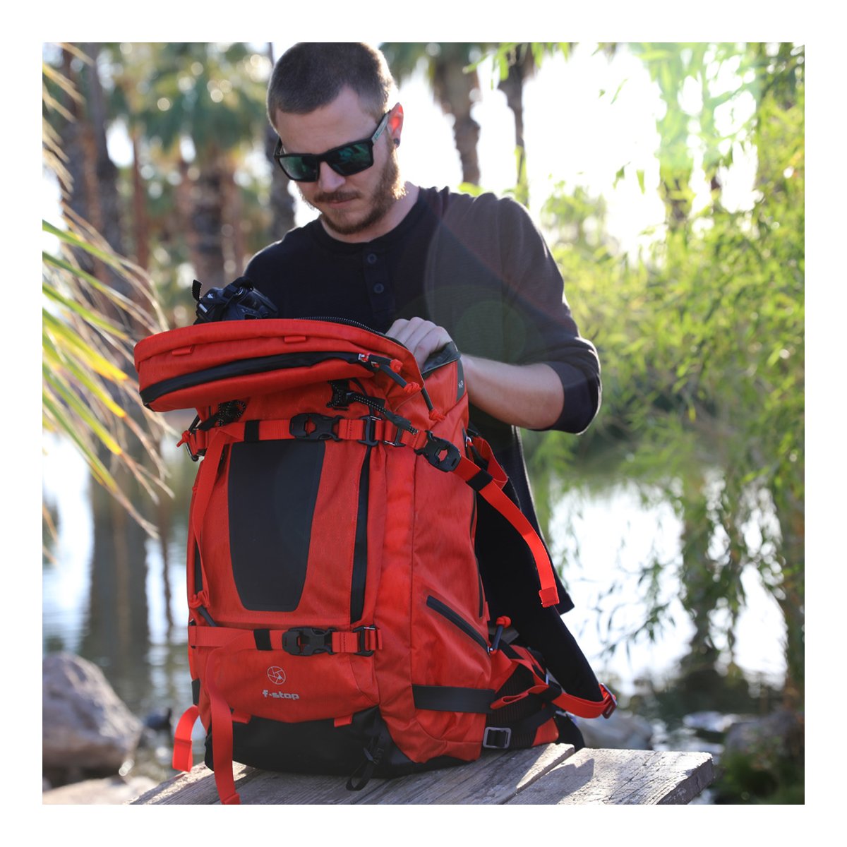 F-Stop DuraDiamond Tilopa - Magma - Anwendungsbeispiel: Mann verstaut Kamera im roten Outdoor-Rucksack. F-Stop DuraDiamond Tilopa - Magma - Anwendungsbeispiel: Mann verstaut Kamera im roten Outdoor-Rucksack.