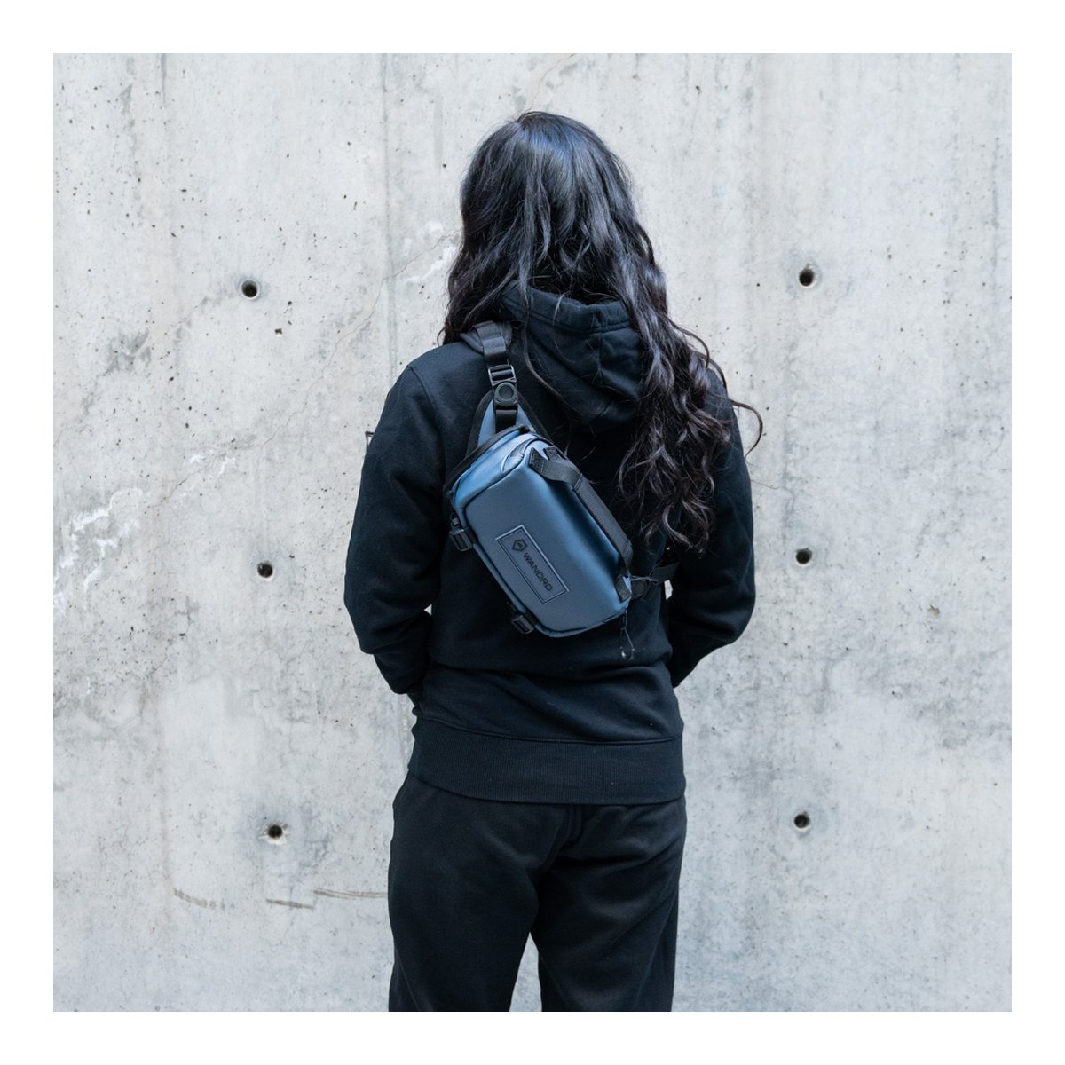 WANDRD ROGUE Sling 3L Aegean Blue - Anwendungsbeispiel: Blaue Sling Bag am Rücken einer Person getragen.