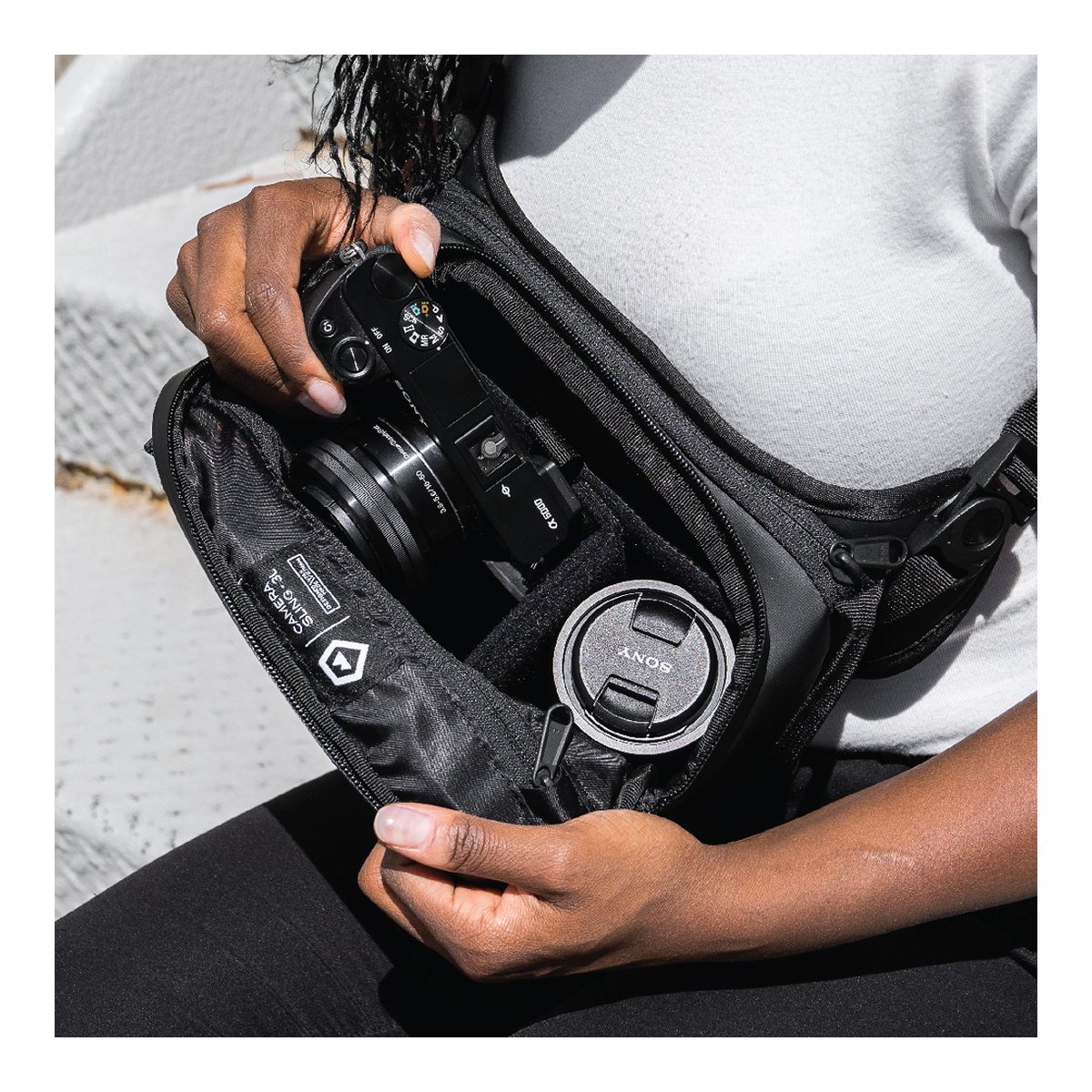 WANDRD ROGUE Sling 3L Black - Anwendungsbeispiel: Innenansicht der Kameratasche mit Kamera und Objektivdeckel.