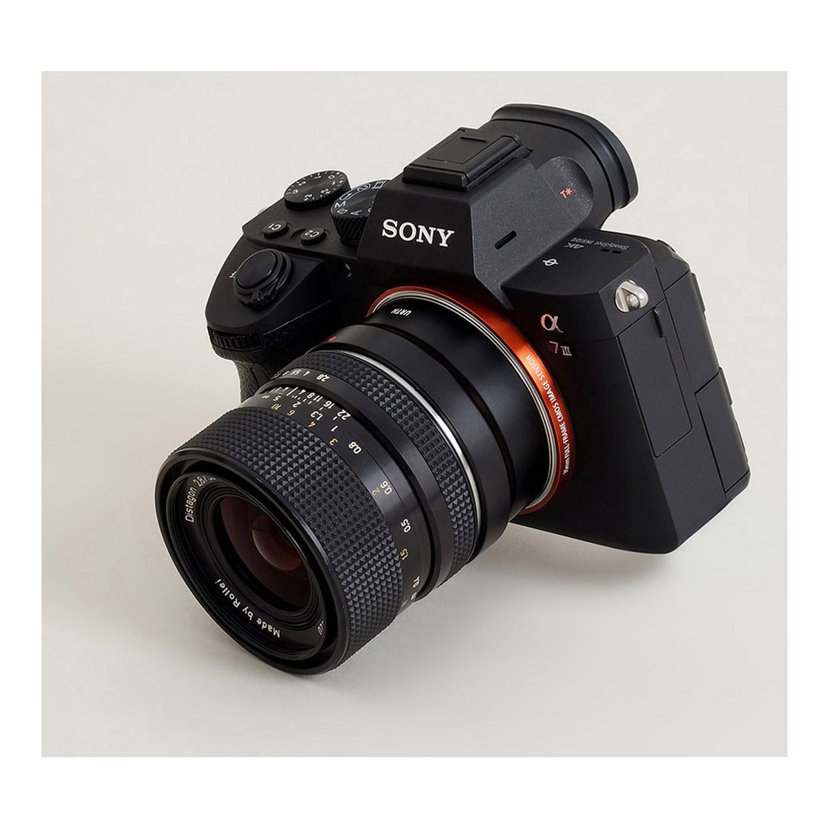 Urth Lens Mount Adapter: Compatible with Rollei SL35 (QBM) Lens to Sony E Camera Body - Schräge Ansicht der Sony Alpha Kamera mit angesetztem Objektiv.