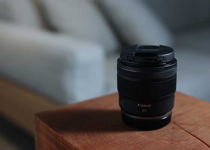 Canon RF 45mm 1.2 STM Objektiv steht auf einem Tisch im Innenraum.