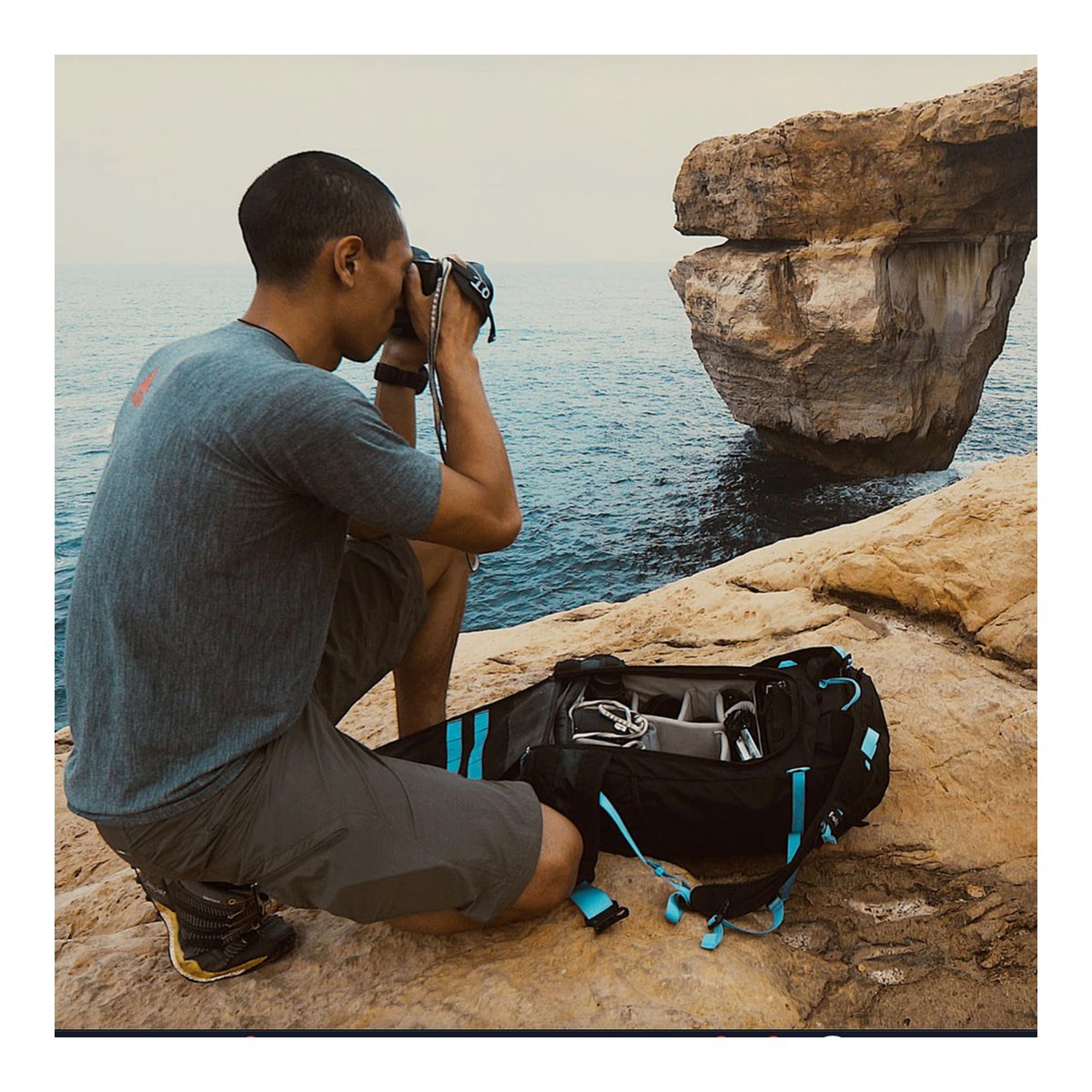 F-Stop Loka UL Essentials Bundle - Anwendungsbeispiel: Offene Tasche mit Fotoausrüstung neben Fotograf am Meer.