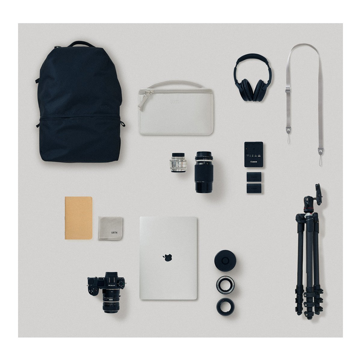 Urth Arkose 20L Rucksack + Kamera Insert (Aschgrau) - Anwendungsbeispiel: Rucksack, Kamera, Laptop, Kopfhörer & Zubehör im Flat Lay auf hellem Hintergrund.