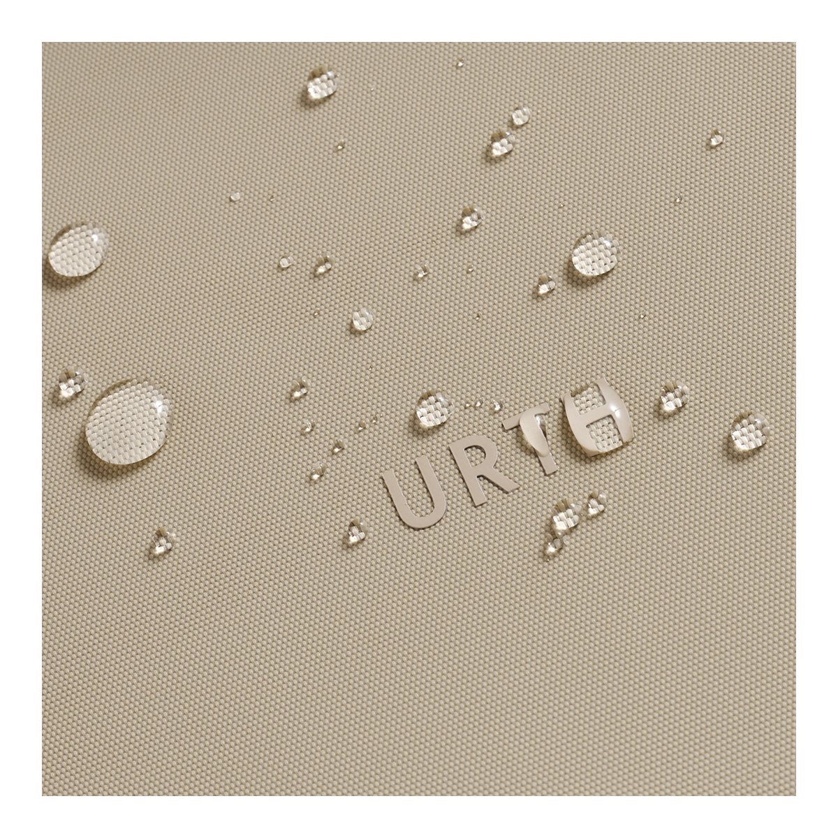 Urth Arkose Camera Insert (Beige) - Nahaufnahme wasserabweisender Stoff mit Wassertropfen und Urth-Schriftzug