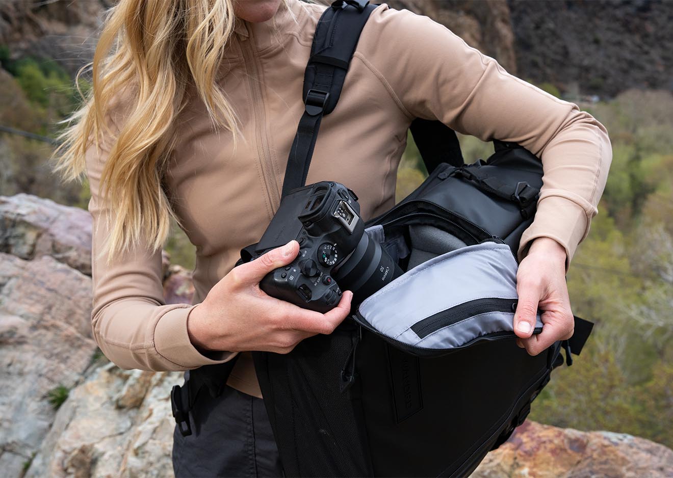 rau entnimmt Kamera aus dem seitlichen Zugang des Wandrd PRVKE Rucksacks