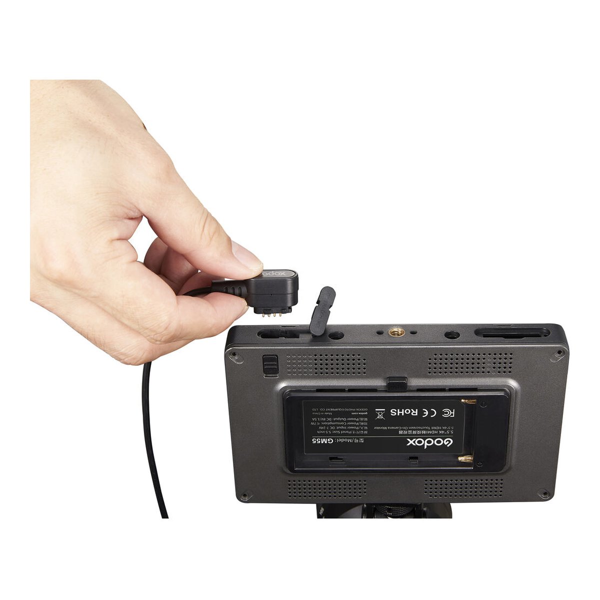 Godox Monitor Kamera-Steuerkabel (Mini USB) - Anwendungsbeispiel: Hand steckt Kabel in Godox GM55 Kamera-Monitor, seitliche Ansicht der Anschlüsse.