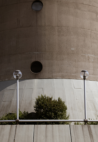Architekturfotografie – Industrielles Design mit geometrischen Strukturen Nahaufnahme eines Industriegebäudes mit runden Fenstern und architektonischen Details. Die Perspektive betont die Struktur und Linienführung.