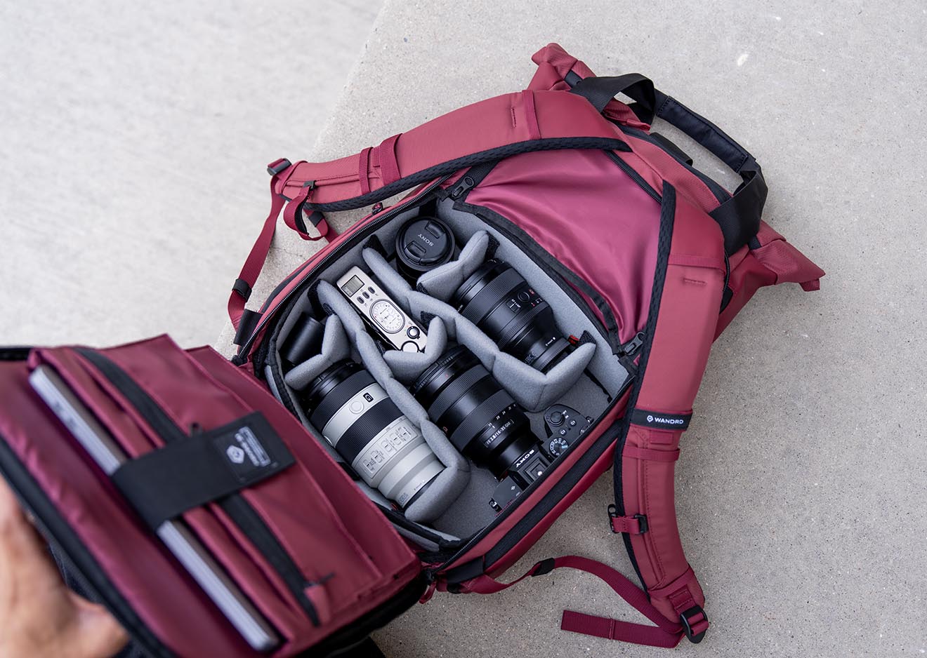 Innenansicht eines PRVKE V4 Rucksacks in Rot mit Kameraausrüstung und Objektiven
