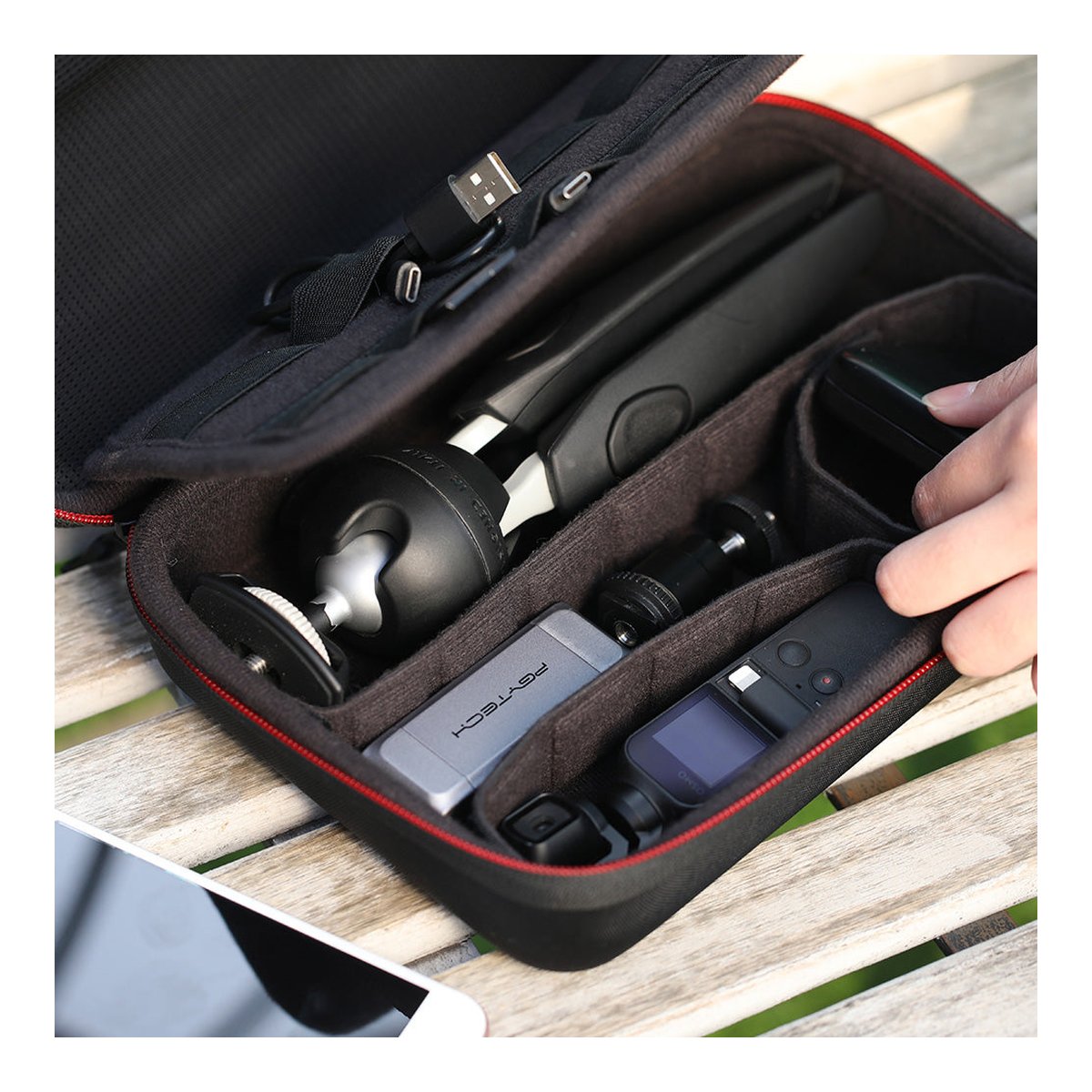 PGYTECH Osmo Pocket Carrying Case - Detailansicht: Geöffnete schwarze Aufbewahrungstasche mit organisiertem Kamera-Zubehör (Stativ, Powerbank, Kamera)