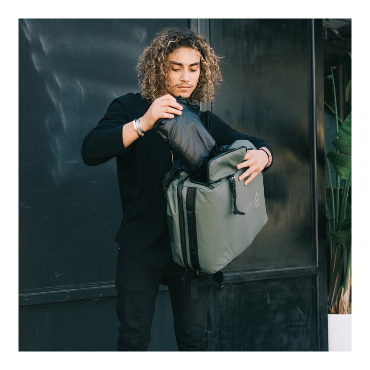 WANDRD HEXAD ACCESS DUFFEL Wasatch Green - Anwendungsbeispiel: Person verstaut kompakte Ausrüstung in grauer Tasche. WANDRD HEXAD ACCESS DUFFEL Wasatch Green - Anwendungsbeispiel: Person verstaut kompakte Ausrüstung in grauer Tasche.