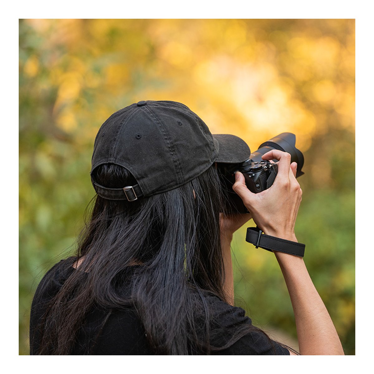 WANDRD Wrist Strap - Anwendungsbeispiel: Kamerahandschlaufe am Handgelenk einer Person mit Kamera.