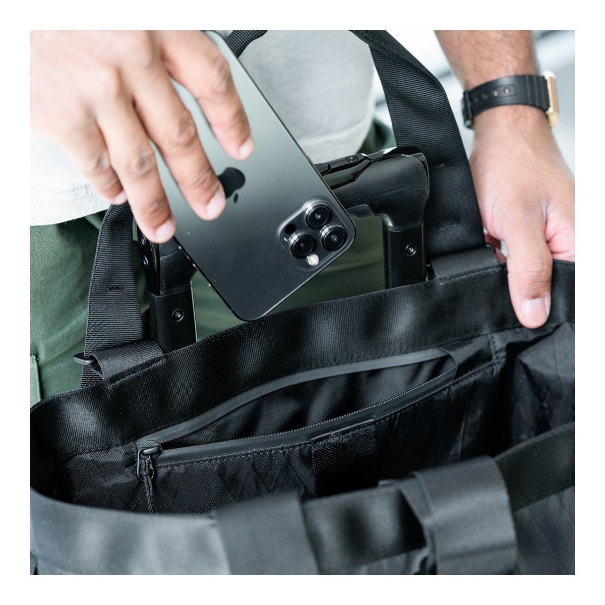 WANDRD Tote Backpack - Anwendungsbeispiel: Smartphone in Reißverschluss-Innentasche der Tasche verstaut. WANDRD Tote Backpack - Anwendungsbeispiel: Smartphone in Reißverschluss-Innentasche der Tasche verstaut.
