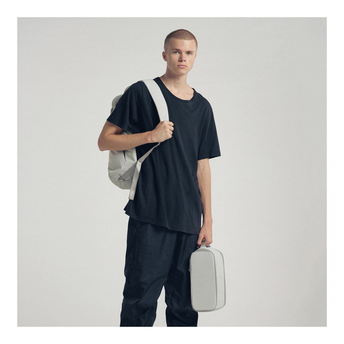 Urth Norite Camera Insert (Aschgrau) - Anwendungsbeispiel: Mann trägt Rucksack und hält passenden Organizer