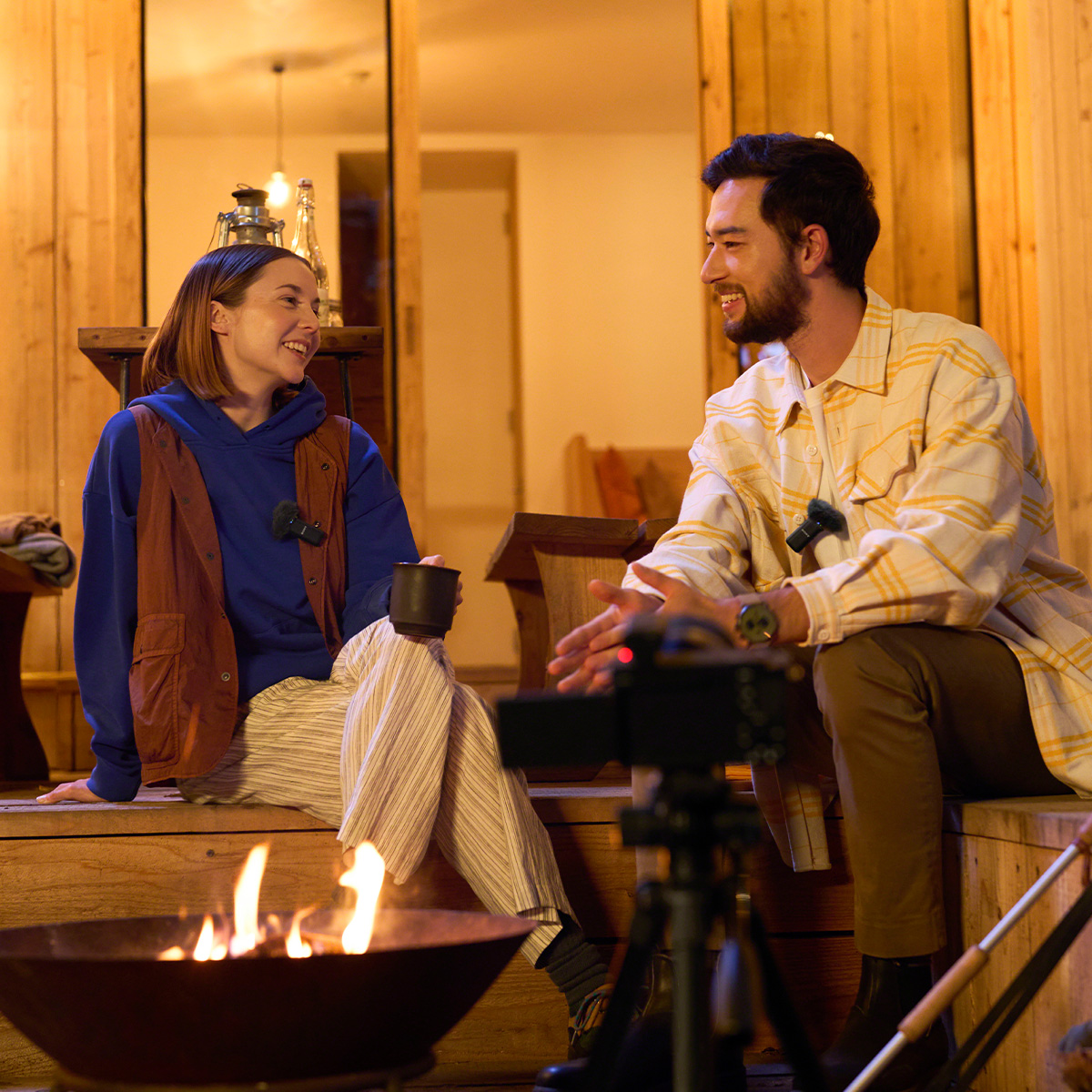Frau und Mann unterhalten sich vor einem Feuer mit dem Sony ECM-W3 Mikrofon 