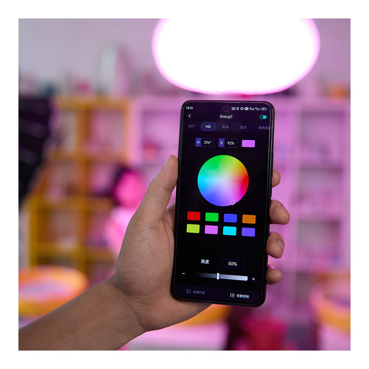 Godox Litemons RGB LED Video Light Kit LA150R K1 - Anwendungsbeispiel: Hand hält Smartphone mit Lichtsteuerungs-App, die Farbauswahl und Helligkeitsregler zeigt.